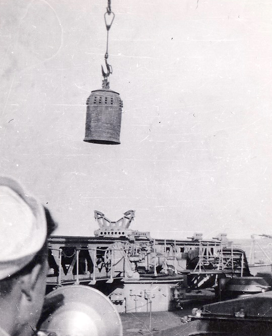 Salvaged Temple Bell being lowered into the fantail hangar deck CA-69 Boston