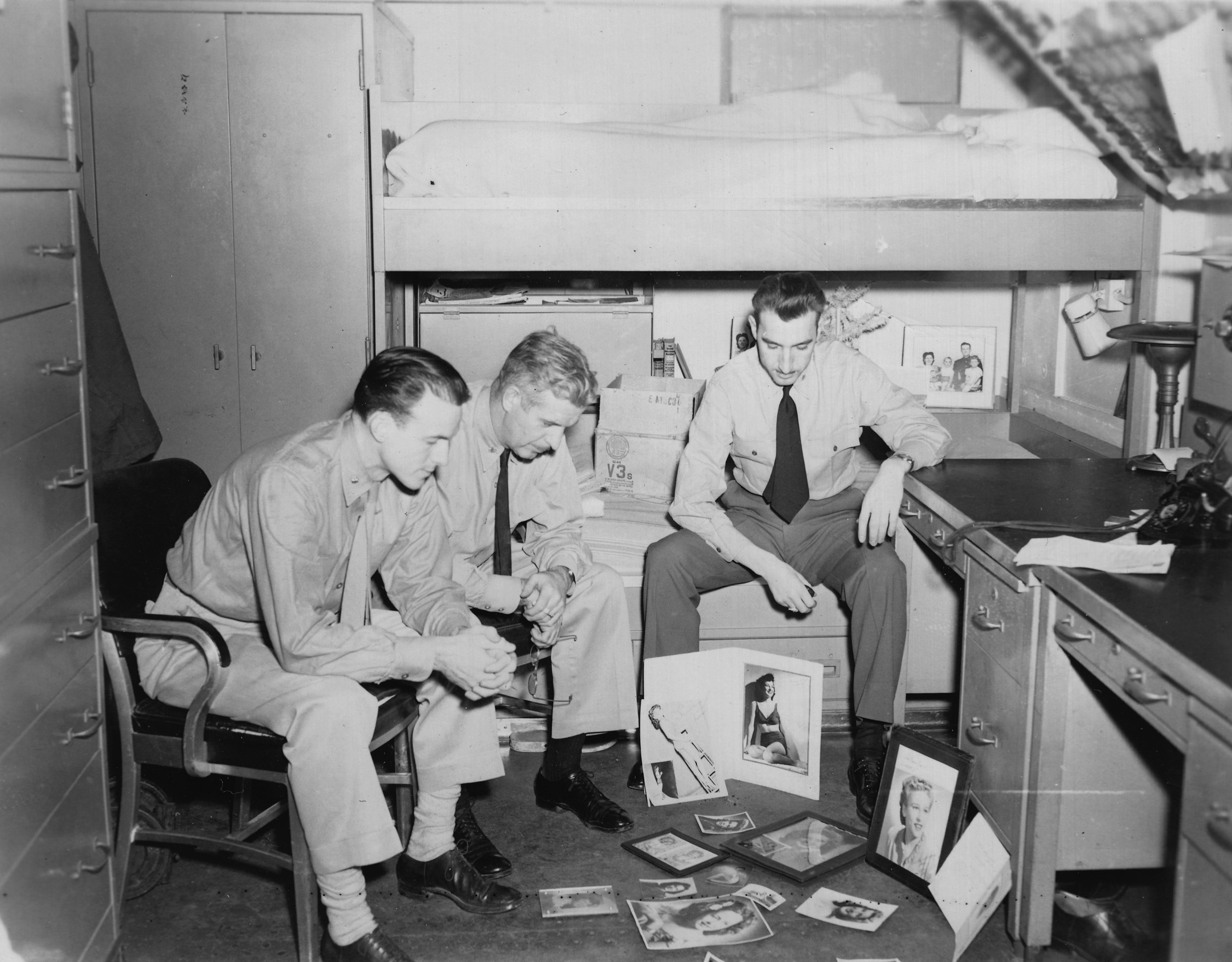 Norm Bayley, (l) in his cabin on the Boston, judging "prettiest girlfriend" contest, in Japanese Waters, Christmas 1945 